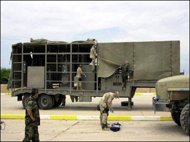 Members of a mobile exploitation team examining a suspected mobile biological weapons facility that was recovered by US Forces in northern Iraq. The trailer resembles one of the mobile laboratories described by US Secretary of State Colin Powell.(AFP/DOD)